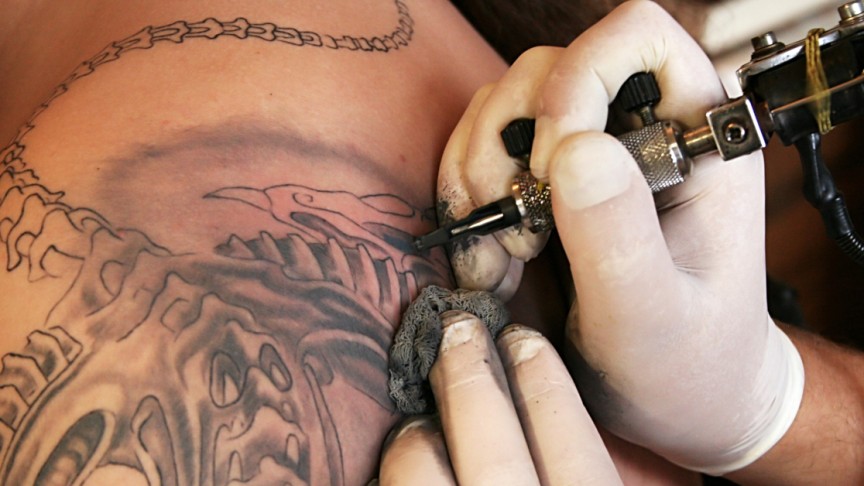What are the potential benefits and risks of using paracetamol before getting a tattoo